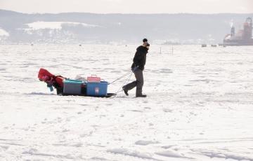 Une personne transportant son matériel pour la pêche blanche au Saguenay